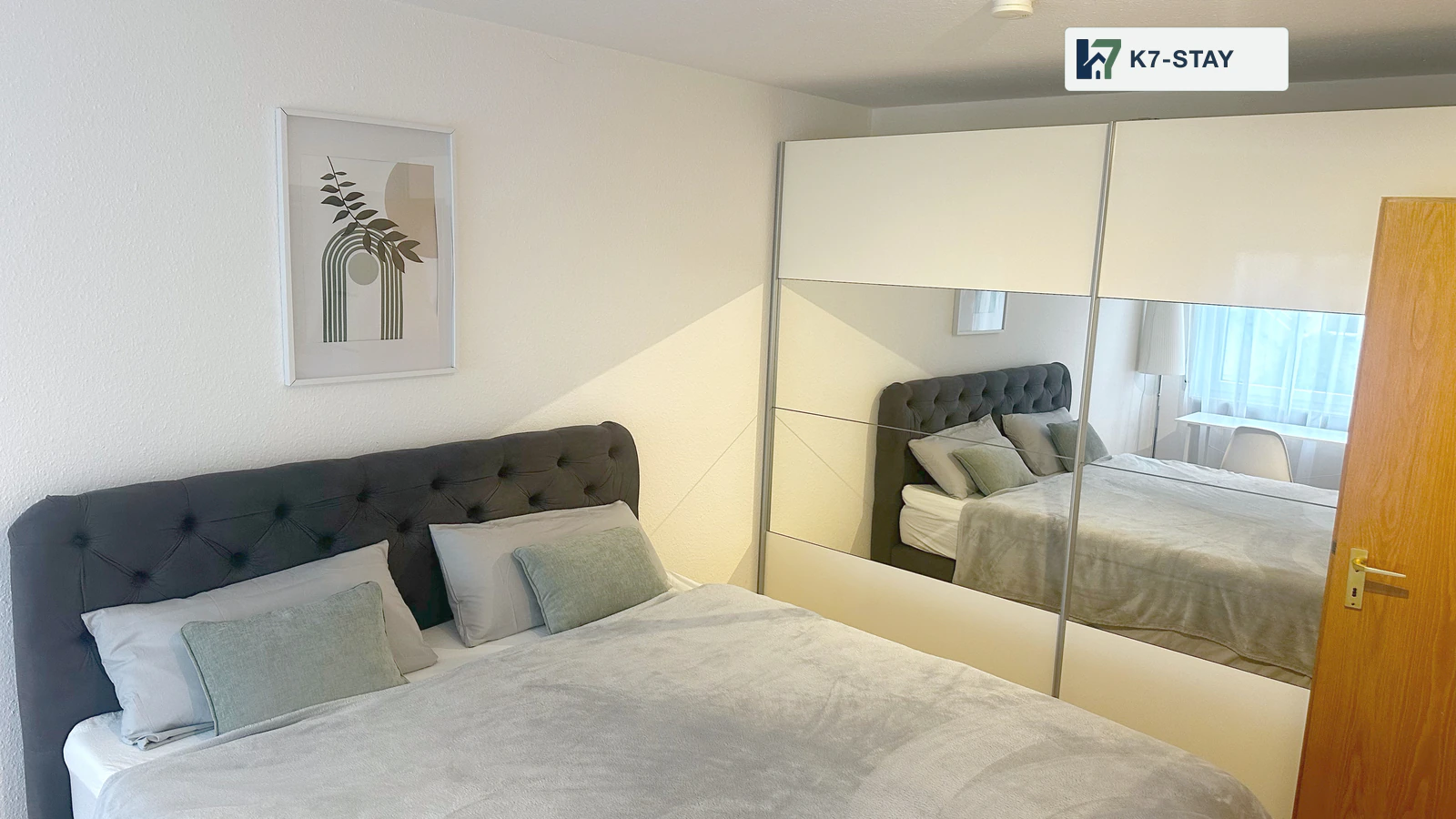 Schlafzimmer mit Doppelbett und kleinem Arbeitsplatz